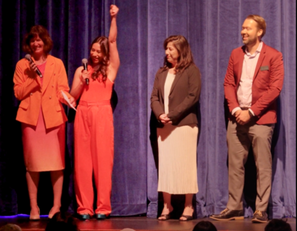 Members of A Step Beyond staff accept grant award on stage